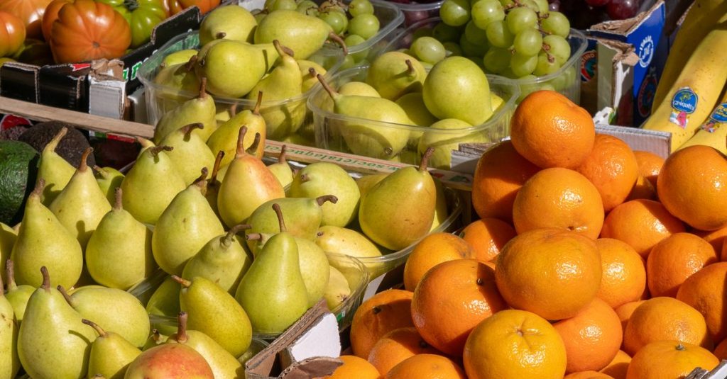 Bright and colorful assortment of fresh fruits at an outdoor market stall.